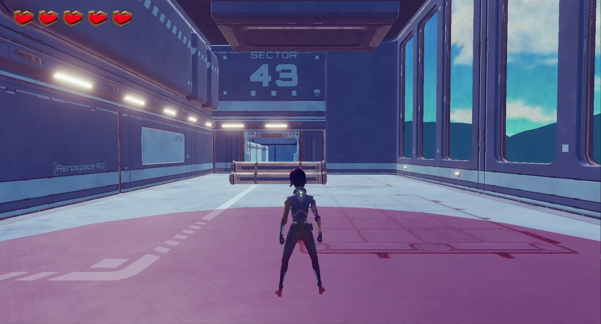 An in-game view of a female character standing inside a medium-sized room. A wall in the distance has the words "Sector 43" written on it, and there are metal tubes in the middle of the room and an open doorway in the distance. Part of the floor is covered in a red circle that is radiating our from the player.