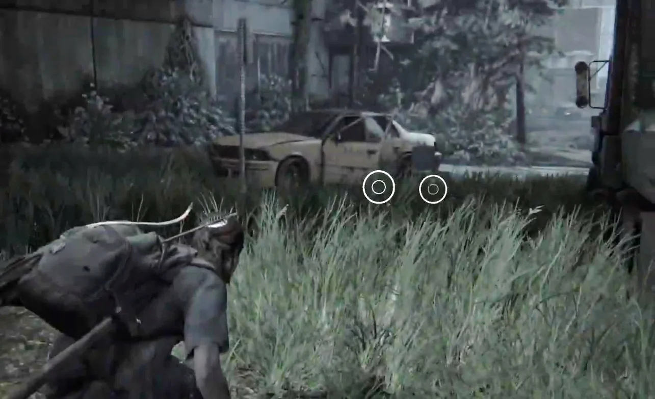 An in-game view of a female character crouching and moving through tall grass. An abandoned car lies in the distance.
